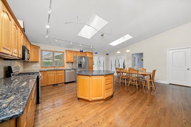 8950 S 84th Ave, Hickory Hills, IL 60457 - kitchen with appliances with stainless steel finishes, a skylight, a kitchen island, light wood-style floors, and decorative backsplash