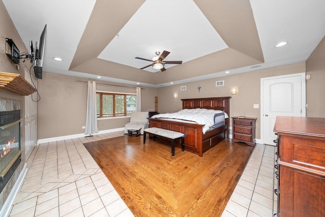 8950 S 84th Ave, Hickory Hills, IL 60457 - bedroom with light tile patterned floors, a raised ceiling, a tile fireplace, recessed lighting, and ceiling fan