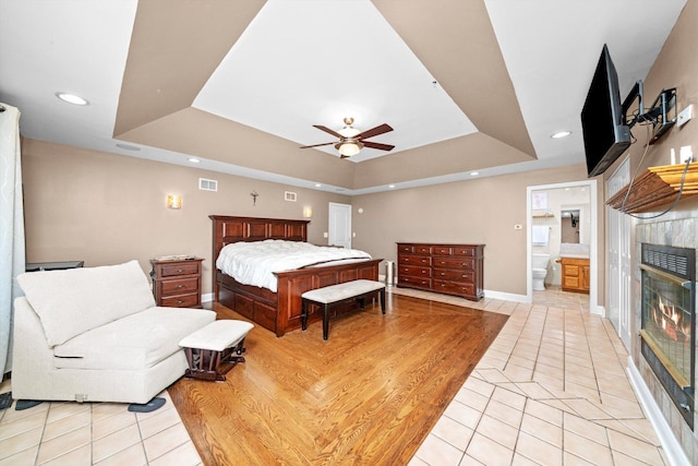8950 S 84th Ave, Hickory Hills, IL 60457 - bedroom with a tray ceiling, light tile patterned floors, a fireplace, recessed lighting, and ceiling fan