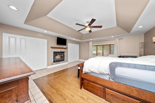 8950 S 84th Ave, Hickory Hills, IL 60457 - tiled bedroom featuring a tray ceiling, a fireplace, recessed lighting, and a ceiling fan