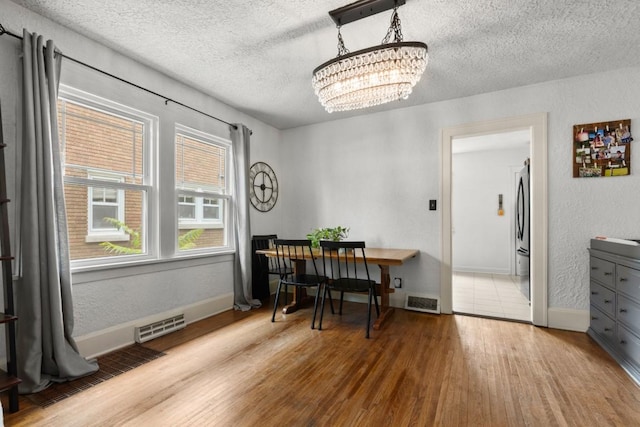 2417 Crosby St, Rockford, IL 61107 - dining area featuring a textured ceiling, wood finished floors, a chandelier, and a textured wall