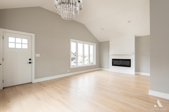 77371/2 Nashville Ave, Burbank, IL 60459 - unfurnished living room featuring plenty of natural light, light wood finished floors, lofted ceiling, a chandelier, and a glass covered fireplace