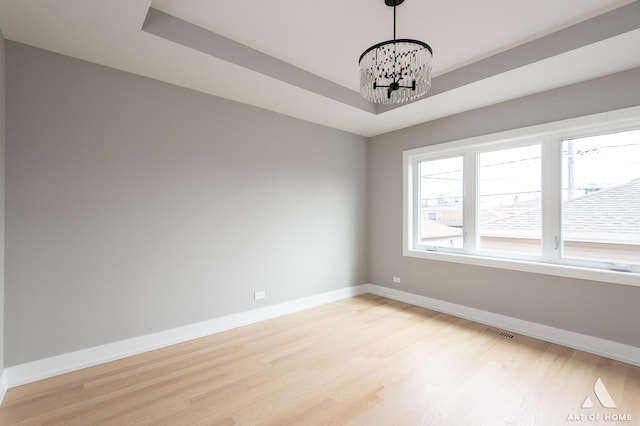 77371/2 Nashville Ave, Burbank, IL 60459 - empty room featuring light wood-type flooring, a chandelier, and a raised ceiling