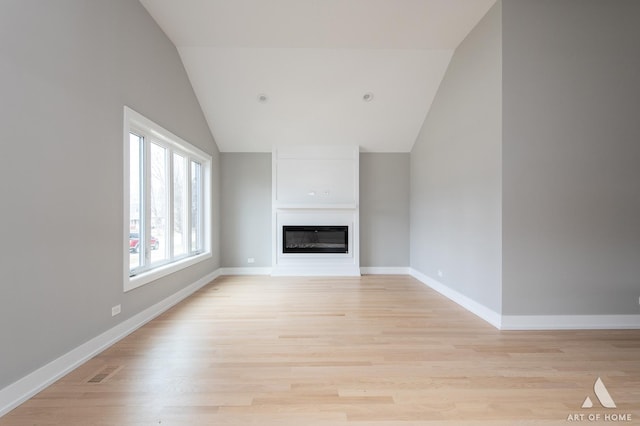 77371/2 Nashville Ave, Burbank, IL 60459 - unfurnished living room with vaulted ceiling, a glass covered fireplace, and light wood-style floors