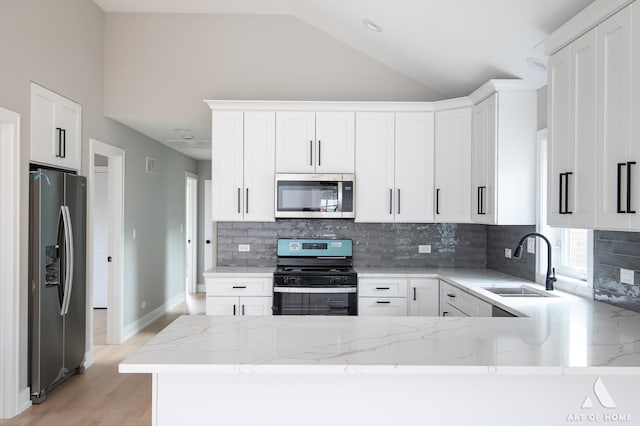 77371/2 Nashville Ave, Burbank, IL 60459 - kitchen with appliances with stainless steel finishes, vaulted ceiling, light stone countertops, decorative backsplash, and a peninsula
