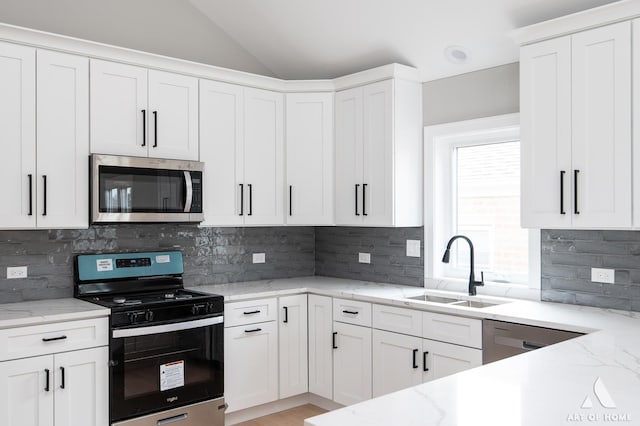 77371/2 Nashville Ave, Burbank, IL 60459 - kitchen with appliances with stainless steel finishes, white cabinetry, vaulted ceiling, and light stone counters