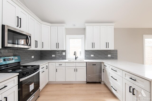 77371/2 Nashville Ave, Burbank, IL 60459 - kitchen featuring appliances with stainless steel finishes, a peninsula, white cabinetry, and tasteful backsplash