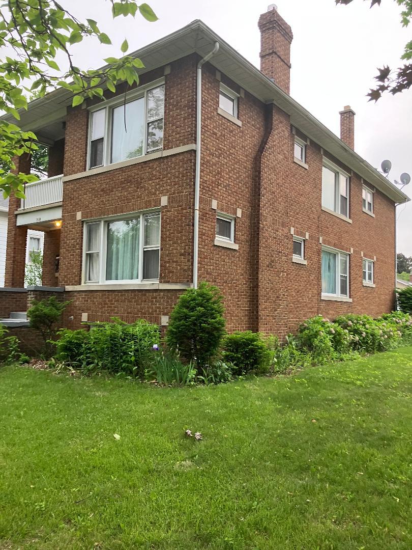 1532 N Ave, Waukegan, IL 60085 - view of side of property featuring brick siding, a chimney, and a yard