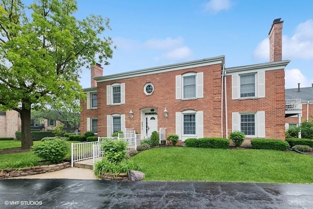 128 Carriage Way Dr Unit 217B, Burr Ridge, IL 60527 - view of front facade with a chimney, brick siding, and a front yard