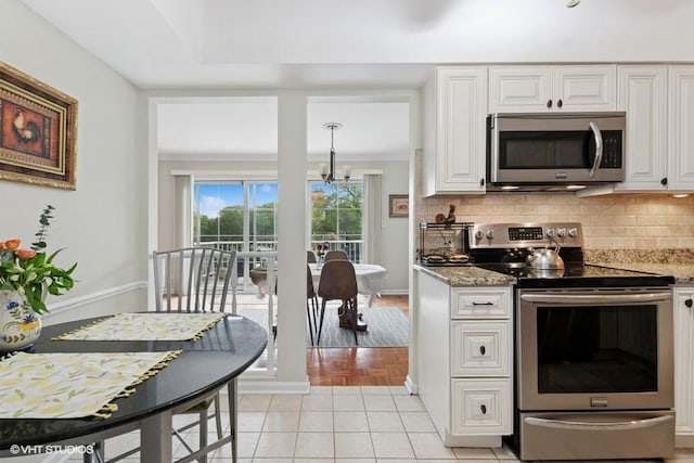 128 Carriage Way Dr Unit 217B, Burr Ridge, IL 60527 - kitchen with stainless steel appliances, white cabinetry, tasteful backsplash, and light stone countertops