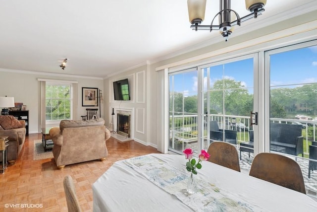 128 Carriage Way Dr Unit 217B, Burr Ridge, IL 60527 - dining space with ornamental molding, a chandelier, and a fireplace