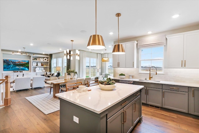 26328 W Sablewood Cir, Plainfield, IL 60585 - kitchen featuring gray cabinetry, hardwood / wood-style floors, a kitchen island, decorative backsplash, and open floor plan