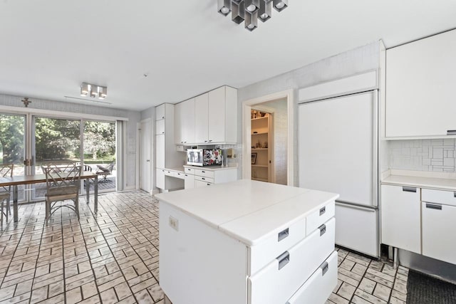 937 Braeburn Rd, Inverness, IL 60067 - kitchen featuring paneled built in refrigerator, light countertops, backsplash, white cabinets, and brick patterned floors