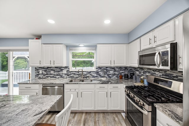 2853 Forestview Dr, Carpentersville, IL 60110 - kitchen with appliances with stainless steel finishes, white cabinets, light stone counters, decorative backsplash, and recessed lighting