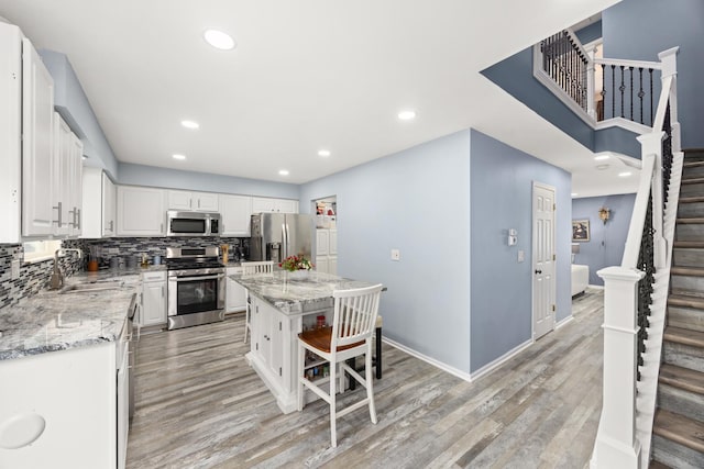 2853 Forestview Dr, Carpentersville, IL 60110 - kitchen with appliances with stainless steel finishes, light wood finished floors, backsplash, white cabinets, and recessed lighting