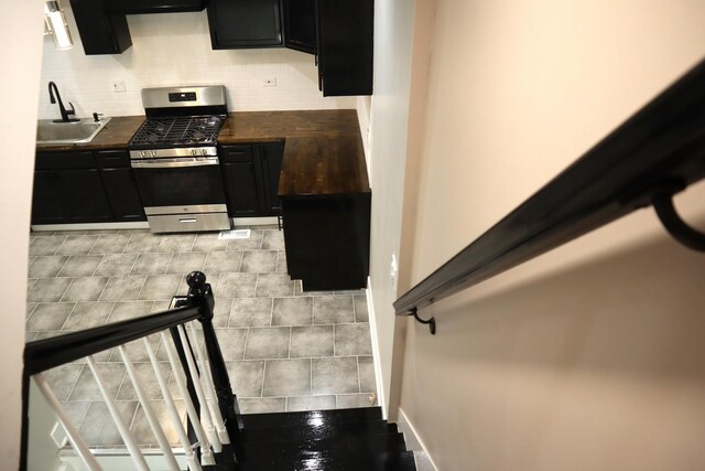 8346 S Baltimore Ave, Chicago, IL 60617 - kitchen with gas stove, dark countertops, dark cabinetry, decorative backsplash, and extractor fan