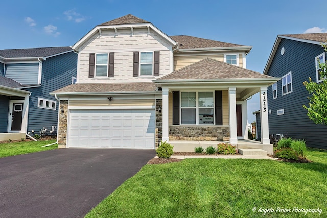 21725 N Ashley St, Kildeer, IL 60047 - craftsman-style house featuring asphalt driveway, covered porch, a garage, stone siding, and a front lawn