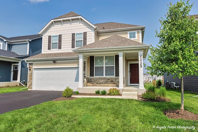 21725 N Ashley St, Kildeer, IL 60047 - craftsman house with driveway, a front yard, an attached garage, stone siding, and roof with shingles