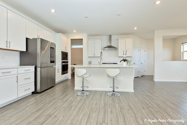 21725 N Ashley St, Kildeer, IL 60047 - kitchen featuring appliances with stainless steel finishes, wall chimney range hood, decorative backsplash, light countertops, and a kitchen bar