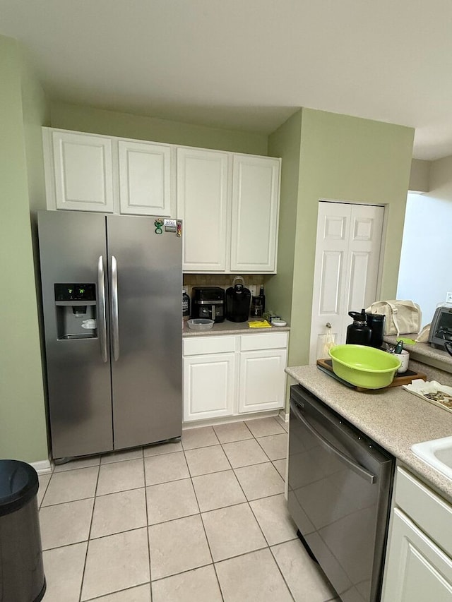 352 Bay Dr, Itasca, IL 60143 - kitchen featuring appliances with stainless steel finishes, white cabinets, light countertops, and light tile patterned floors