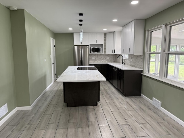 656 Springfield Ave, Joliet, IL 60435 - kitchen featuring appliances with stainless steel finishes, a center island, white cabinetry, open shelves, and tasteful backsplash