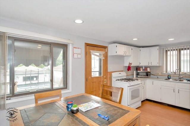 5716 W 64th Pl, Chicago, IL 60638 - kitchen with white gas range, white cabinets, light countertops, recessed lighting, and light wood-type flooring