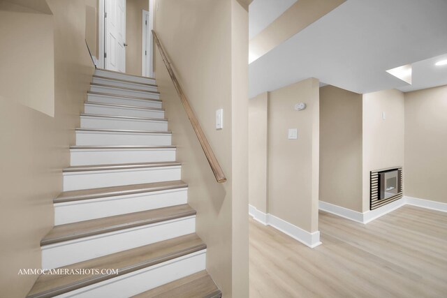 5029 W Superior St, Chicago, IL 60644 - staircase with wood finished floors, a glass covered fireplace, and recessed lighting