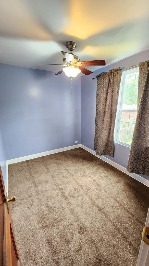 8127 S Blackstone Ave, Chicago, IL 60619 - unfurnished room featuring carpet floors and a ceiling fan