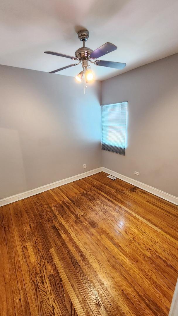 8127 S Blackstone Ave, Chicago, IL 60619 - unfurnished room with a ceiling fan and wood finished floors
