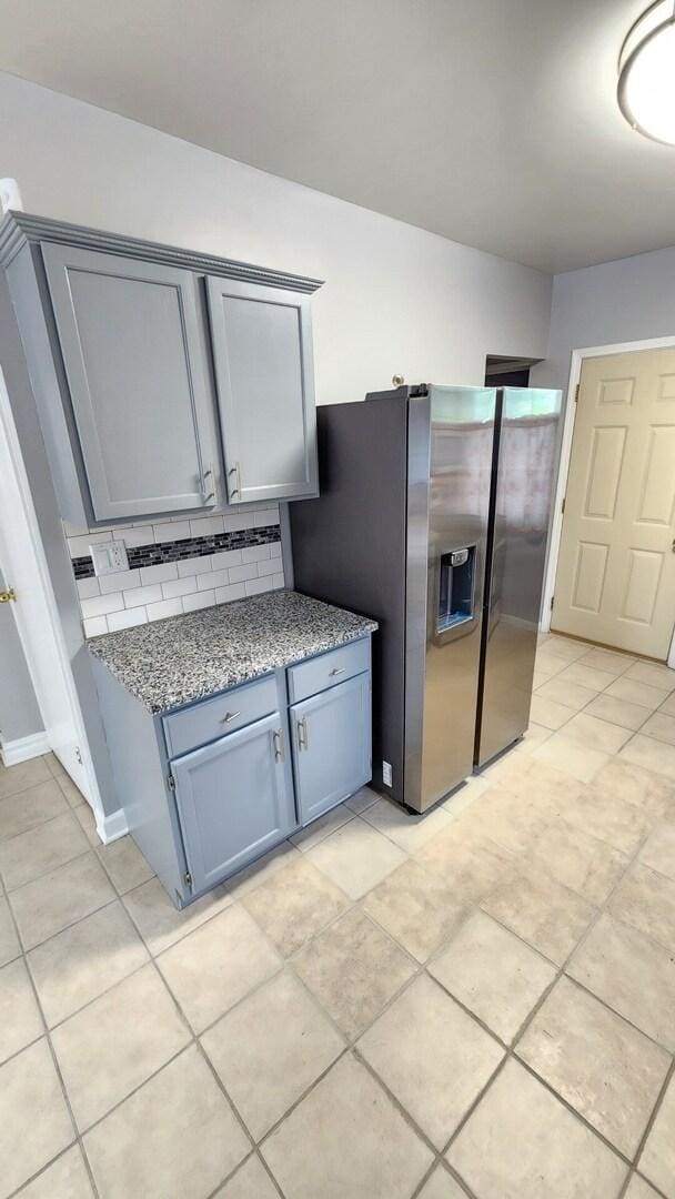 8127 S Blackstone Ave, Chicago, IL 60619 - kitchen with tasteful backsplash, gray cabinetry, light stone countertops, stainless steel refrigerator with ice dispenser, and light tile patterned flooring