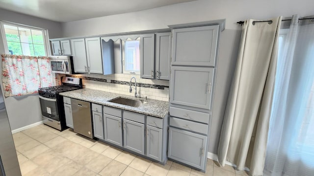 8127 S Blackstone Ave, Chicago, IL 60619 - kitchen with gray cabinetry, appliances with stainless steel finishes, decorative backsplash, and light stone countertops