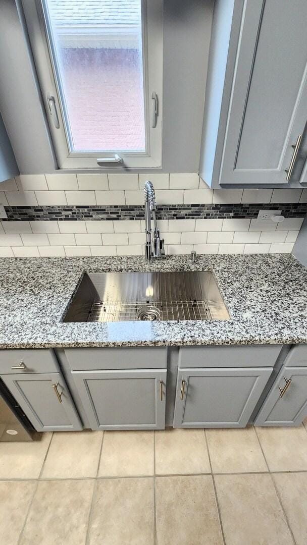 8127 S Blackstone Ave, Chicago, IL 60619 - kitchen view of gray cabinets, backsplash, and light stone countertops