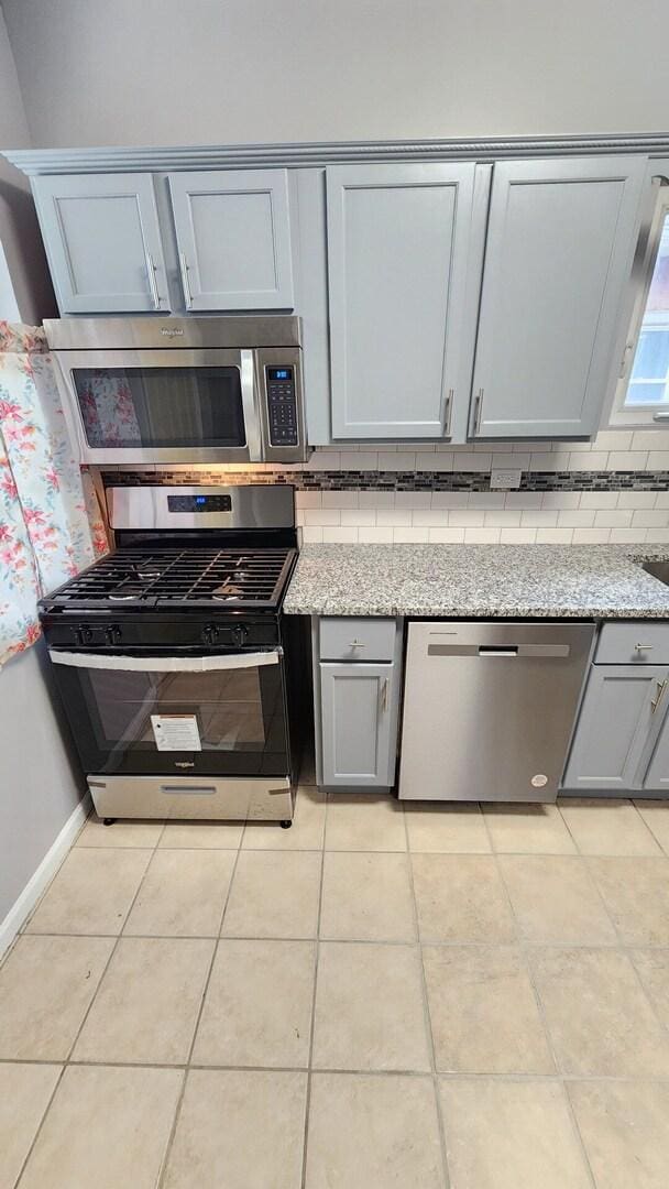 8127 S Blackstone Ave, Chicago, IL 60619 - kitchen featuring stainless steel appliances, gray cabinetry, tasteful backsplash, and light tile patterned floors
