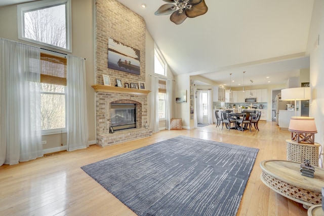 1218 Birchdale Ln, Aurora, IL 60504 - living area featuring high vaulted ceiling, a ceiling fan, light wood-type flooring, a fireplace, and recessed lighting