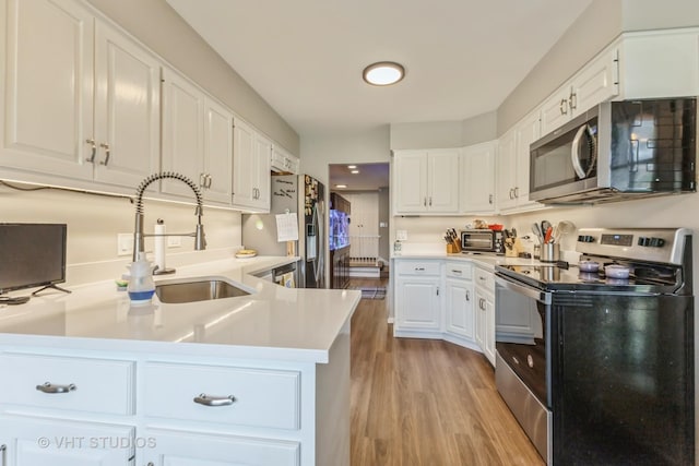 7930 W Lakeview Ct Unit 2A, Palos Heights, IL 60463 - kitchen with appliances with stainless steel finishes, light wood-type flooring, white cabinetry, and light countertops