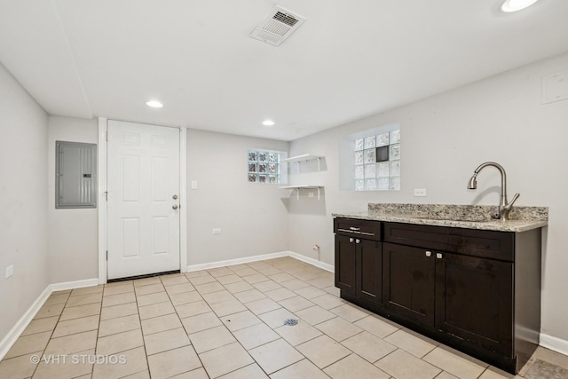 5155 W George St, Chicago, IL 60641 - kitchen with electric panel, recessed lighting, light stone countertops, and dark brown cabinetry