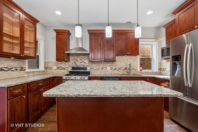 5155 W George St, Chicago, IL 60641 - kitchen featuring appliances with stainless steel finishes, wall chimney exhaust hood, a kitchen island, dark wood finished floors, and recessed lighting