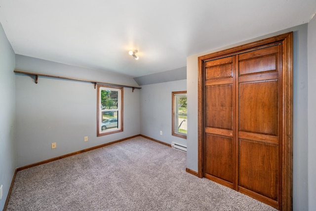 557 E Mckinley St, Hinckley, IL 60520 - unfurnished bedroom featuring a baseboard heating unit, carpet, and vaulted ceiling