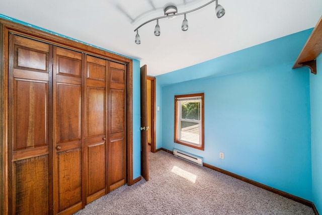 557 E Mckinley St, Hinckley, IL 60520 - unfurnished bedroom with a baseboard heating unit, light carpet, and a closet