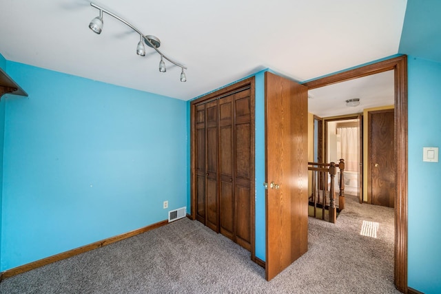557 E Mckinley St, Hinckley, IL 60520 - unfurnished bedroom with carpet, a closet, and rail lighting