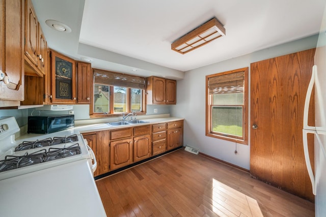 557 E Mckinley St, Hinckley, IL 60520 - kitchen with brown cabinets, light countertops, fridge, and light wood-type flooring