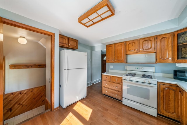 557 E Mckinley St, Hinckley, IL 60520 - kitchen with white appliances, light countertops, and brown cabinetry