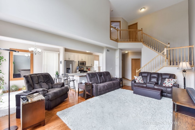 497 Le Moyne Ave, Romeoville, IL 60446 - living area with stairs, light wood-style flooring, a chandelier, and a high ceiling