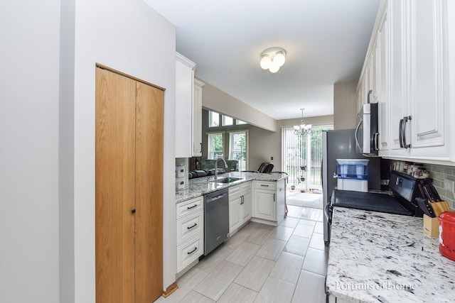 497 Le Moyne Ave, Romeoville, IL 60446 - kitchen featuring appliances with stainless steel finishes, white cabinets, decorative backsplash, a chandelier, and a peninsula