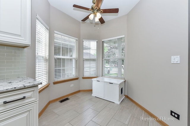 497 Le Moyne Ave, Romeoville, IL 60446 - unfurnished dining area with a ceiling fan and baseboards