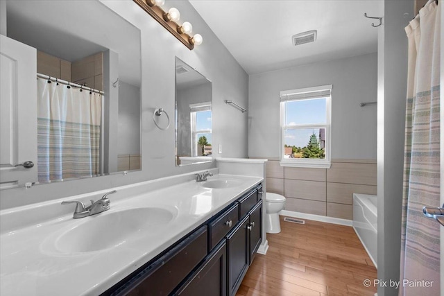 911 Water Stone Way, Malta, IL 60150 - full bath with tile walls, double vanity, wood finished floors, wainscoting, and a tub