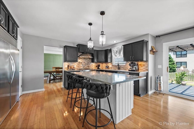 911 Water Stone Way, Malta, IL 60150 - kitchen featuring built in fridge, backsplash, light stone countertops, and a breakfast bar area