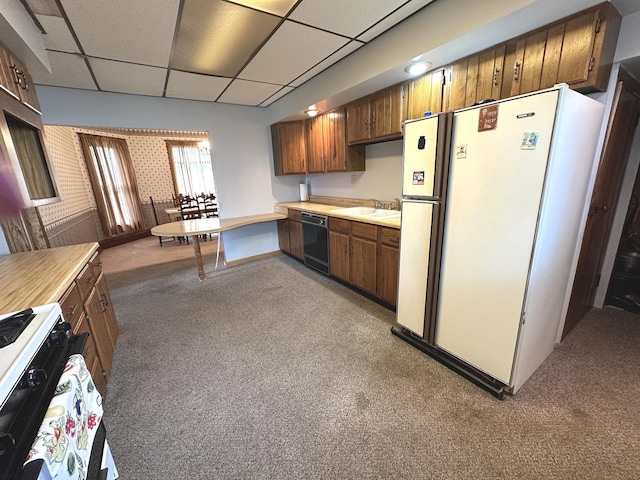 506 E Lincoln St, Saybrook, IL 61770 - kitchen with white appliances, a paneled ceiling, light countertops, light carpet, and brown cabinets