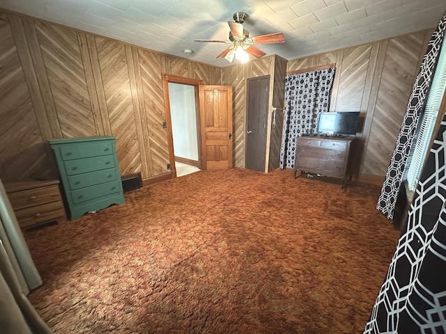 506 E Lincoln St, Saybrook, IL 61770 - unfurnished bedroom featuring carpet flooring, wood walls, and a ceiling fan