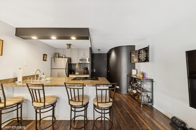 1221 N Dearborn St Unit 608S, Chicago, IL 60610 - kitchen featuring freestanding refrigerator, a peninsula, black electric stovetop, a kitchen breakfast bar, and dark wood-type flooring